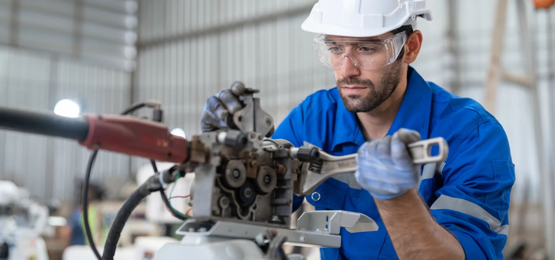 Técnico executando manutenção mecânica em máquina de produção industrial
