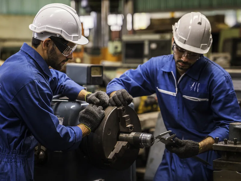 Equipe realizando montagem mecânica de equipamento industrial em fábrica